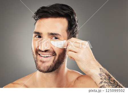 Man, eye patch and product for skincare, beauty and health with a smile for cosmetic, collagen and dermatology. Male, happy and face portrait with young model advertising healthy skin and wellness Man, eye patch and product for skincare, beauty and health with a smile for cosmetic, collagen and dermatology. Male, happy and face portrait with young model advertising healthy skin and wellness 125099502
