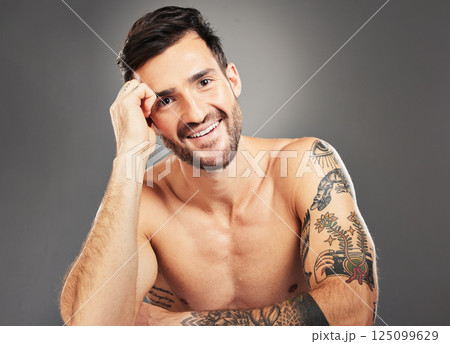 Man, beauty and sexy with body, tattoo and happy portrait against grey studio background with mockup space. Male model, sexy and smile for self care, skincare and cosmetic wellness with clean face 125099629