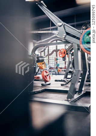 Gym interior, fitness and exercise with gym equipment and weightlifting for body training, health and wellness. Weights, muscle and strong for cardio and endurance with metal and steel for workout. 125099745