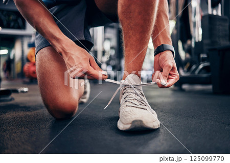 Gym, hands and man tie shoes getting ready for workout, training or exercise. Fitness, sports or male athlete in fitness center preparing for running, cardio or bodybuilding practice in health studio 125099770
