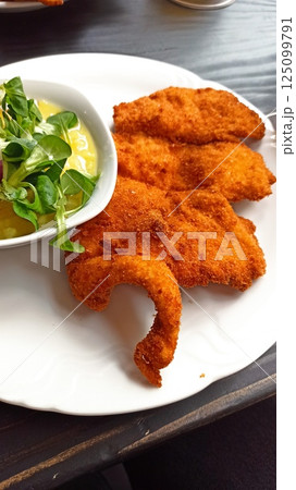 Crispy breaded schnitzel served on white plate Crispy breaded schnitzel served on white plate 125099791
