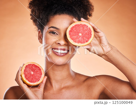 Grapefruit, skincare and portrait of black woman with a beauty, organic and natural routine. Cosmetics, citrus fruit and African model with cosmetic facial treatment in studio with orange background. 125100049