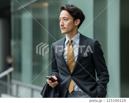 スマートフォンを持った若いおしゃれなビジネスマン 125100129