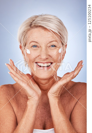 Beauty, portrait of mature woman and cream for skincare, anti aging and wellness on a grey studio background. Skin care, moisturiser or lotion with a senior female apply suncream or spf on her face 125100234