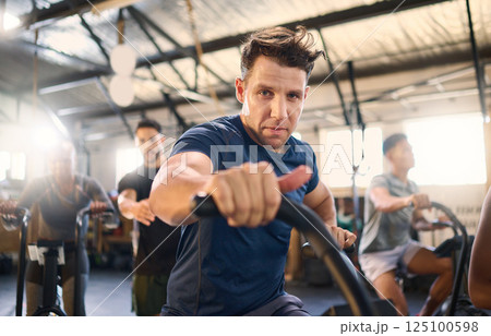 Bike, class and exercise man portrait with cycling training, wellness and fitness gym group. Athlete with motivation doing a bicycle, sports and spinning workout at a health cub or studio with people 125100598