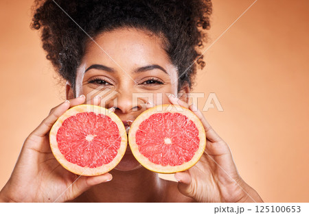 Grapefruit, black woman and vitamin c beauty, skincare and wellness, healthy body and aesthetics, natural cosmetics and face on studio background. Portrait of african model, citrus nutrition and diet 125100653