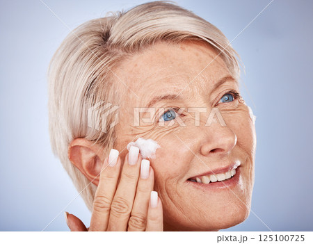Skincare, thinking and senior woman with cream for face against a grey studio background. Sunscreen, happy and elderly model with an idea with a facial dermatology product for beauty and self care 125100725