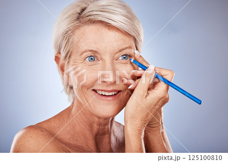 Face, beauty and eyeliner with a senior woman in studio on a gray background to apply cosmetics. Makeup, beautiful and eye pencil with a mature female applying a cosmetic product to her face 125100810