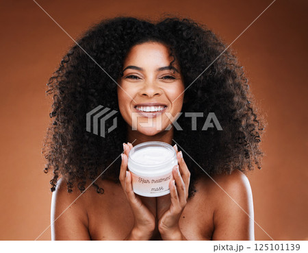 Cosmetics, cream and black woman with hair, face mask or natural beauty with brown studio background. African American female, confident girl and hair care for healthy scalp, smile and curly afro. 125101139