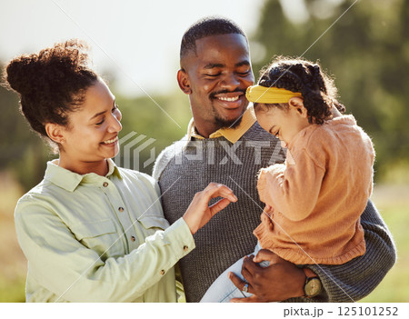 Love, family and happy girl with parents in a park, laughing and playing while bonding in nature. Love, happy family and child relax, play and enjoy quality time with mother and father in a forest 125101252