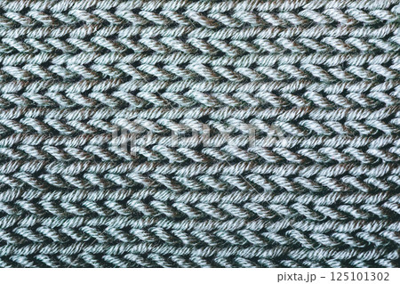 A close up of a knitted fabric with a grayish color A close up of a knitted fabric with a grayish color 125101302