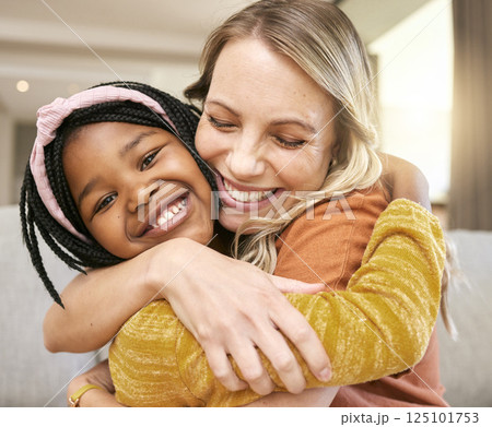 Portrait, family and adoption with a girl and mother hugging in a living room of their house together. Face, love and children with a foster parent woman and daughter embracing while bonding at home 125101753
