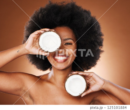 Coconut, studio and black woman natural face, skincare and hair promotion with mockup for healthy food or product marketing. African model portrait with facial cream coconut oil for health benefits Coconut, studio and black woman natural face, skincare and hair promotion with mockup for healthy food or product marketing. African model portrait with facial cream coconut oil for health benefits 125101884
