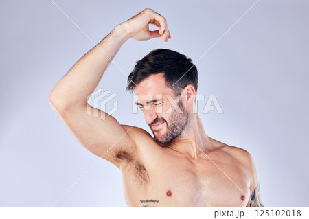 Armpit, stink and hygiene with a man model smelling his underarm in studio on a gray background for a deodorant product. Body, natural and sweat with a handsome young male sniffing his sweaty arm Armpit, stink and hygiene with a man model smelling his underarm in studio on a gray background for a deodorant product. Body, natural and sweat with a handsome young male sniffing his sweaty arm 125102018