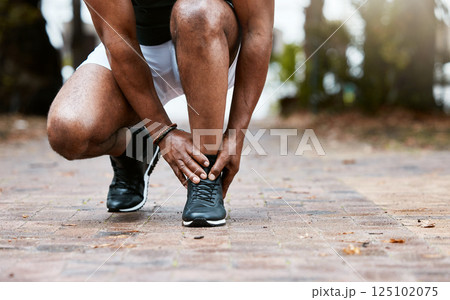 Sports injury, ankle pain and fitness accident of a man doing massage on feet for physical therapy after exercise, workout and training. Athlete runner outdoor for orthopedic health problem on ground Sports injury, ankle pain and fitness accident of a man doing massage on feet for physical therapy after exercise, workout and training. Athlete runner outdoor for orthopedic health problem on ground 125102075