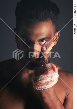 Blood, boxing injury and man with bruise from fight conflict, criminal violence or dark crime with middle finger emoji sign. Shadow, rebel lifestyle and portrait of mma boxer with first aid bandage 125102114