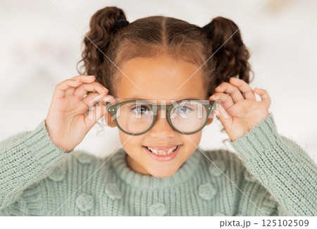 Glasses, frame and portrait of child with vision, eye care and eyes healthcare, wellness and insurance trust, choice and shopping. Happy kid with lens check, test or assessment at an optometry store 125102509