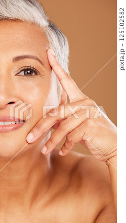 Old woman, beauty and half face portrait in studio isolated on a brown background. Luxury makeup, cosmetics and retired elderly female model thinking about facial skincare, health and skin wellness. Old woman, beauty and half face portrait in studio isolated on a brown background. Luxury makeup, cosmetics and retired elderly female model thinking about facial skincare, health and skin wellness. 125102582