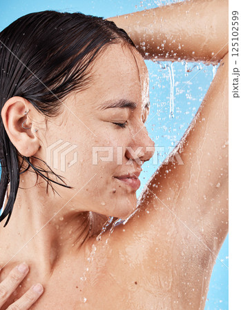 Shower, woman and water for wellness, health and body care, wet and cleaning against blue studio background. Splash, female and healthy girl washing, clean and bathroom grooming for hygiene and relax Shower, woman and water for wellness, health and body care, wet and cleaning against blue studio background. Splash, female and healthy girl washing, clean and bathroom grooming for hygiene and relax 125102599