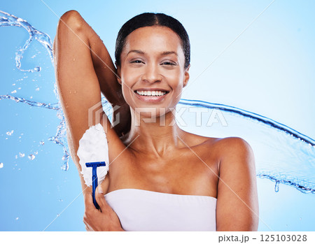 Black woman, armpit shaving with cream and razor, beauty for grooming, shower water splash with blue studio background. Hygiene, foam product and clean, skincare portrait and cosmetic hair removal. Black woman, armpit shaving with cream and razor, beauty for grooming, shower water splash with blue studio background. Hygiene, foam product and clean, skincare portrait and cosmetic hair removal. 125103028