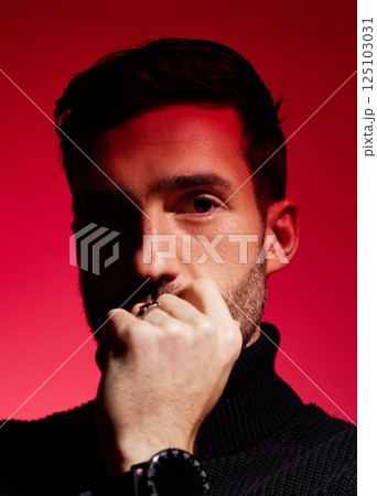 Face, thinking and red with a man model in studio on a color wall background for idea or contemplation. Fashion, portrait and creative with a handsome young male posing against a red background alone 125103031
