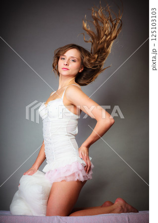 Woman on bed with pillow and wind in hair. Woman on bed with pillow and wind in hair. 125103103