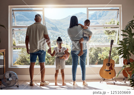 Family, love and window back view in home looking at mountain. Support, trust and baby, mother and father holding hands of girl in house with scenic view, enjoying quality time together and bonding. Family, love and window back view in home looking at mountain. Support, trust and baby, mother and father holding hands of girl in house with scenic view, enjoying quality time together and bonding. 125103669