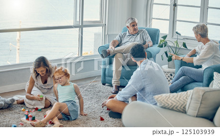 Family, generations and love together in living room with parents, grandparents and child play with toys and bonding. Big family, men with women and kid at home, spending quality time and care. Family, generations and love together in living room with parents, grandparents and child play with toys and bonding. Big family, men with women and kid at home, spending quality time and care. 125103939