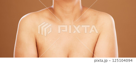 Woman, chest and skincare on a brown studio background for health, wellness and breast cancer awareness. Human body, skin and bust of a female model posing naked for healthcare and self care Woman, chest and skincare on a brown studio background for health, wellness and breast cancer awareness. Human body, skin and bust of a female model posing naked for healthcare and self care 125104094