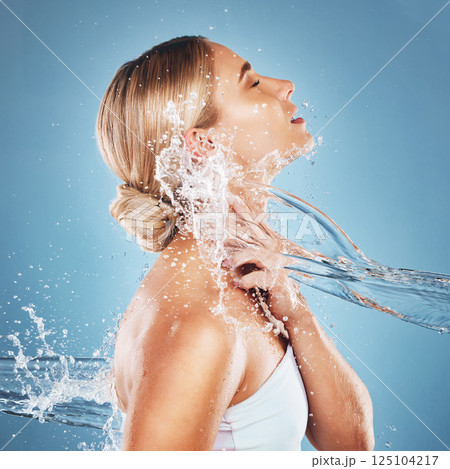 Woman, water and hydration for beauty skincare cosmetics, hygiene or clean moisture against a blue studio background. Female relax in body care cleaning for luxury hydrated skin or cosmetic treatment Woman, water and hydration for beauty skincare cosmetics, hygiene or clean moisture against a blue studio background. Female relax in body care cleaning for luxury hydrated skin or cosmetic treatment 125104217