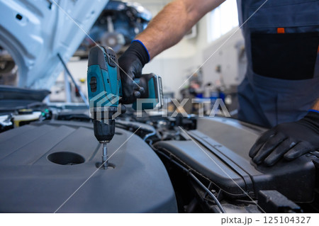 Bearded male technician in shop doing diagnostics and vehicle maintenance Bearded male technician in shop doing diagnostics and vehicle maintenance 125104327
