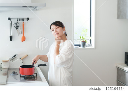 料理する女性（考える・悩む） 125104354
