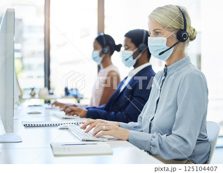 Covid, call center and customer service with a business woman a work in a sales or telemarketing office. Corona, crm and contact us with a female consultant in a mask working in support or retail Covid, call center and customer service with a business woman a work in a sales or telemarketing office. Corona, crm and contact us with a female consultant in a mask working in support or retail 125104407