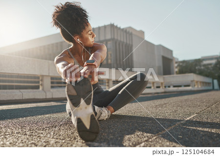 Fitness, city and woman stretching her legs in the street before a cardio workout, running or training. Sports, health and lady doing a warm up stretch for an outdoor exercise in the urban town road. 125104684