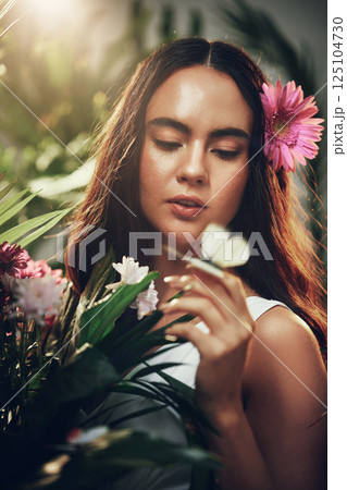 Flowers, natural and woman in a garden during spring for peace, zen and beauty with plants. Summer, gardening and nature girl with flower for ecology in a forest, woods or bush environment to relax 125104730