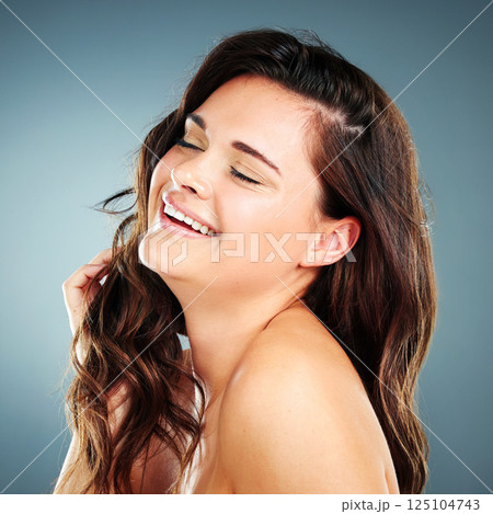 Beauty, skincare and hair care of woman in studio happy about cosmetics, makeup and keratin shampoo for shine and growth. Face of aesthetic model on blue background with glow from dermatology facial 125104743