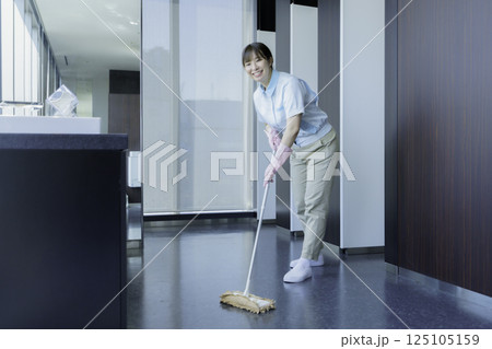 オフィスビルの洗面所の床を拭く若い女性清掃員　撮影協力：学校法人電波学園 東京電子専門学校 125105159