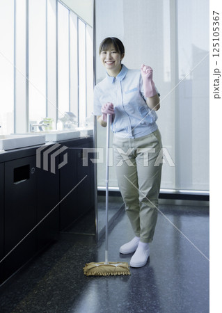 洗面所の床を拭く若い女性清掃員の全身のポートレート　撮影協力：学校法人電波学園 東京電子専門学校 125105367