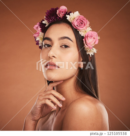 Flower, crown and woman with beauty, makeup and portrait against a brown studio background. Spring, cosmetics and face of a young model with flowers for summer, harmony and accessory in hair 125105538