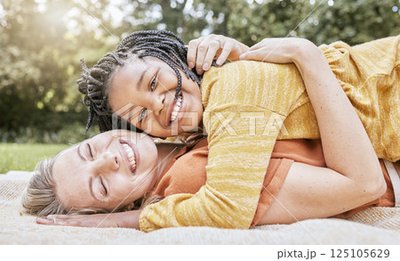 Happy family, mother hug and nature of a interracial girl and mama with love in a picnic park. Portrait of happy, relax and smile of a mother and daughter together on a floor with diversity adoption 125105629