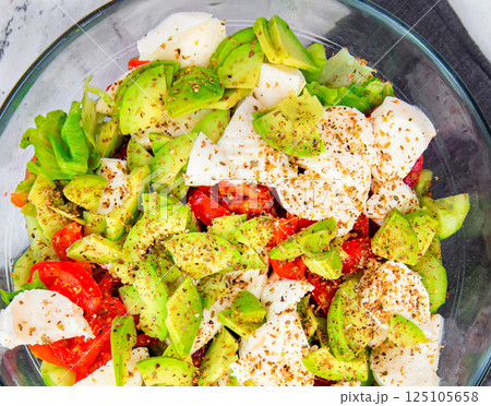Healthy and diet food: salad with lettuce, avocado, tomatoes and mozzarella Healthy and diet food: salad with lettuce, avocado, tomatoes and mozzarella 125105658