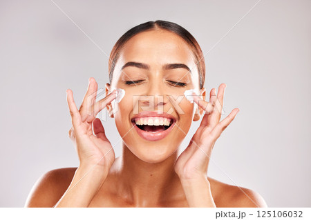Skincare, beauty and woman with face cream in a studio doing a natural face and skin routine. Cosmetic, wellness and happy girl model with facial lotion, spf or sunscreen isolated by gray background. Skincare, beauty and woman with face cream in a studio doing a natural face and skin routine. Cosmetic, wellness and happy girl model with facial lotion, spf or sunscreen isolated by gray background. 125106032