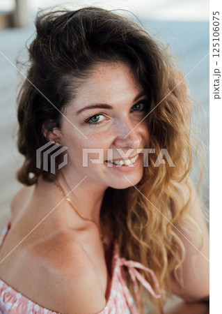 Woman smiling in summer light dress in park on walk Woman smiling in summer light dress in park on walk 125106075