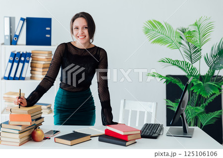 Woman in business suit working at desk in office Woman in business suit working at desk in office 125106106