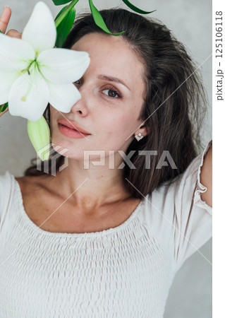 Portrait of a beautiful brunette woman in a light summer dress on a light background 125106118