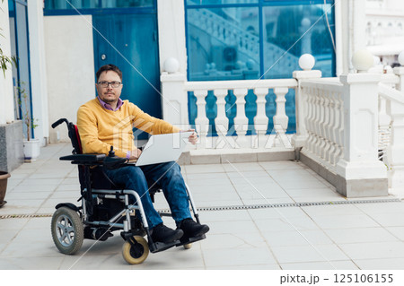 Man in wheelchair working with laptop negotiating business Man in wheelchair working with laptop negotiating business 125106155