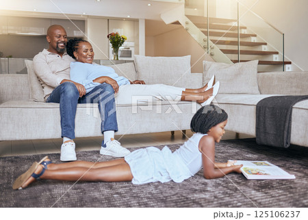 Black family, relax and child reading a book or fantasy story for children entertainment in house living room. Smile, mother and happy father relaxing on sofa with an African girl learning in Kenya 125106237