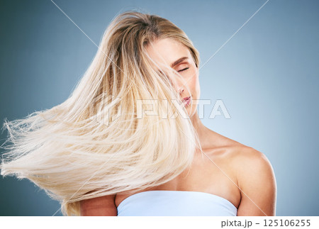 Hair care, young woman and with natural beauty, happy and treatment for cosmetics, pride and with blue studio background. Hair flip, girl or female with makeup, happiness or hair style for confidence Hair care, young woman and with natural beauty, happy and treatment for cosmetics, pride and with blue studio background. Hair flip, girl or female with makeup, happiness or hair style for confidence 125106255