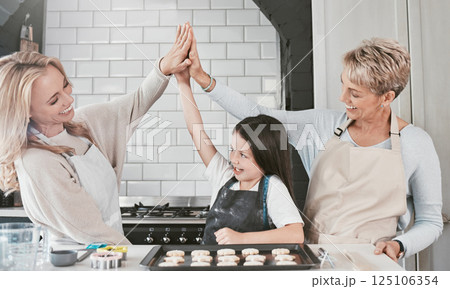 Baking, high five and child with mother and grandmother for success, support and teamwork in the kitchen. Goal, motivation and girl kid with mom and senior woman for cookies in the family home 125106354