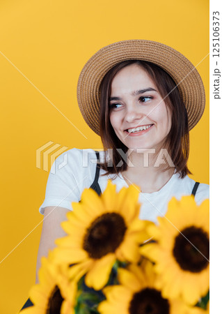 Beautiful woman smiling with yellow sunflower flowers Beautiful woman smiling with yellow sunflower flowers 125106373
